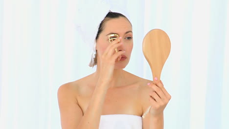 Brunette-woman-using-an-eyelashescurler-