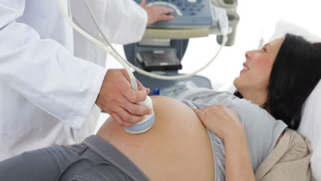 Brunette-pregnant-woman-having-a-sonogram-scan