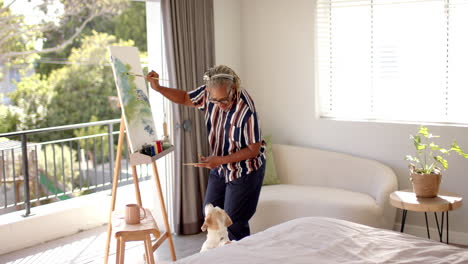 A-senior-African-American-woman-is-painting-on-canvas