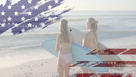 Animation-of-flag-of-usa-over-happy-caucasian-women-with-surfboards-on-beach-in-summer