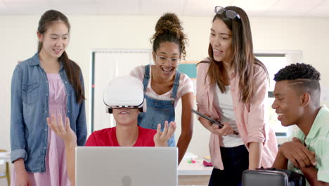 Un-Grupo-Diverso-De-Adolescentes-En-La-Escuela-Secundaria-Explora-La-Realidad-Virtual,-Uno-De-Ellos-Usando-Un-Auricular-VR
