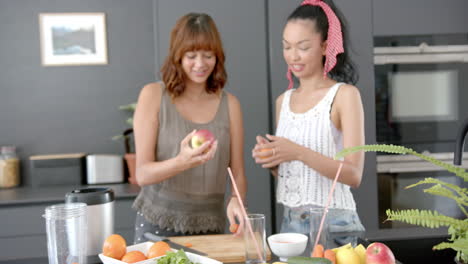 Zwei-Junge-Frauen-Mit-Gemischter-Abstammung-Bereiten-Obst-In-Einer-Modernen-Küche-Zu