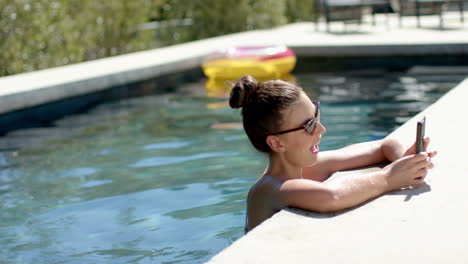 Kaukasische-Frau-Entspannt-Im-Pool,-Trägt-Sonnenbrille,-Kopierraum
