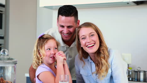 Little-girl-having-milk-and-cookies-with-her-parents