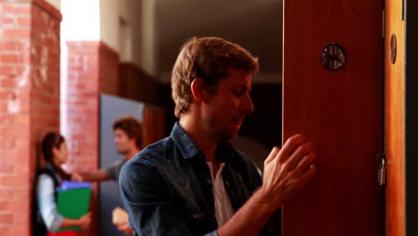 Depressed-student-walking-to-his-locker-and-opening-it