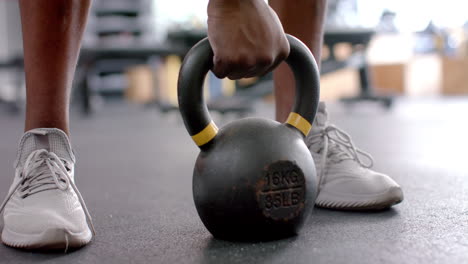 Close-up-of-a-16-kg-kettlebell-being-lifted-by-an-African-American-man-in-a-gym