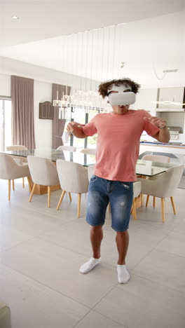Vertical-video:-A-young-biracial-male-dances-in-his-living-room-wearing-VR-headset