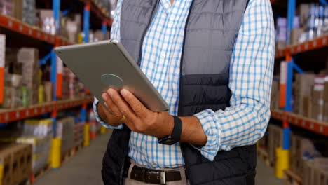 Warehouse-worker-using-his-tablet