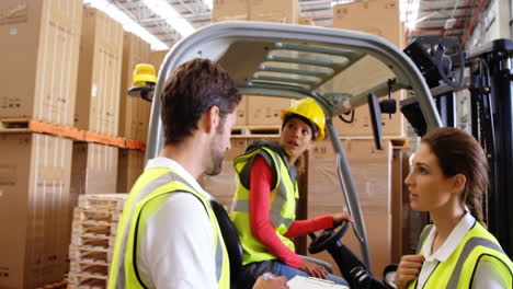Warehouse-workers-interacting-with-forklift-driver