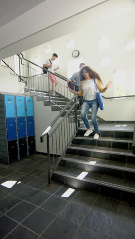 In-Einem-Vertikalen-Video-Einer-Highschool-Läuft-Eine-Bunt-Gemischte-Gruppe-Von-Schülern-Eine-Treppe-Hinunter