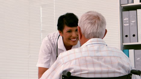 Nurse-talking-to-an-old-man-in-a-wheelchair