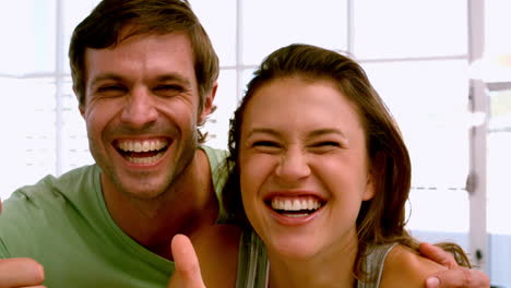 Fit-couple-showing-thumbs-up-to-camera