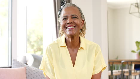 Mujer-Mayor-Afroamericana-Parada-En-Una-Habitación-Luminosa,-Sonriendo