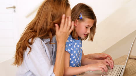 Kleines-Mädchen-Mit-Laptop-Mit-Ihrer-Hübschen-Mutter-Am-Tisch