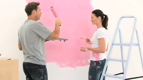 Glückliches-Paar-Malt-Eine-Wand-In-Rosa