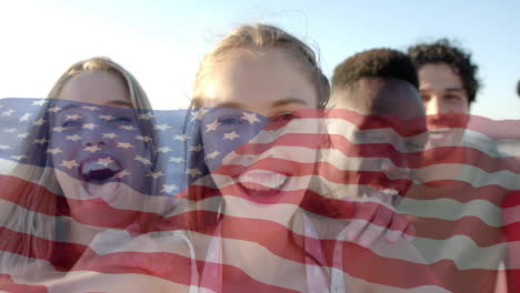 Animation-of-flag-of-usa-over-happy-diverse-friends-on-beach-in-summer