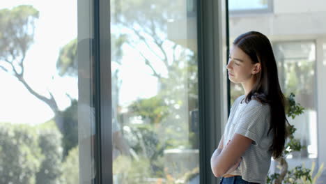 Una-Adolescente-Caucásica-Con-Cabello-Castaño-Está-Pensando-Junto-A-Una-Ventana-Con-Espacio-Para-Copiar-En-Casa