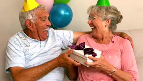 Senior-couple-celebrating-a-birthday-on-the-couch