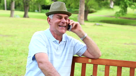 Retired-man-talking-on-the-phone-on-a-park-bench