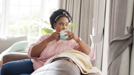 African-American-woman-enjoys-a-warm-drink-at-home