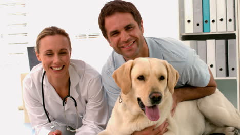 Vet-with-dog-and-dog-owner-smiling-at-camera