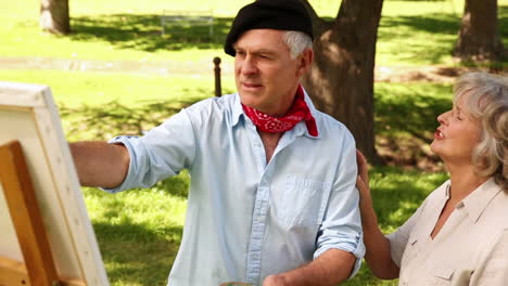 Retired-man-painting-outside-with-his-wife