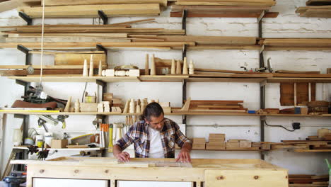 Facing-view-of-carpenter-working-building-a-piece-of-furniture