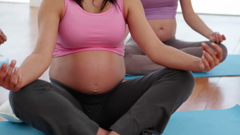 Pregnant-women-doing-yoga-in-fitness-studio