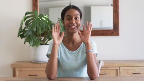 A-young-African-American-woman-gestures-with-her-hands-while-talking-on-a-video-call