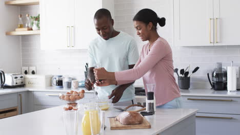 A-diverse-couple-prepares-breakfast-in-modern-kitchen