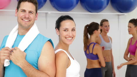 Aerobics-instructor-and-fit-brunette-smiling-at-camera-together