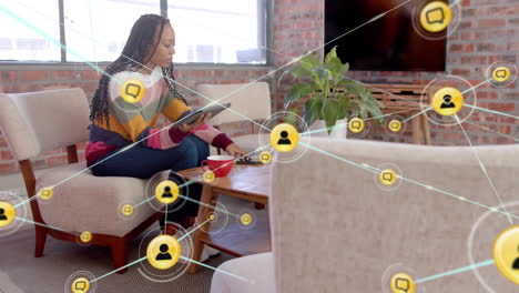 Animation-Eines-Netzwerks-Von-Verbindungen-Mit-Symbolen-über-Einer-Gemischtrassigen-Geschäftsfrau,-Die-Ein-Tablet-Verwendet