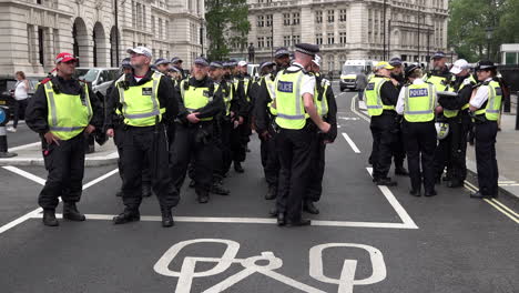 A-unit-of-Metropolitan-police-officers-in-riot-uniforms-stand-in-formation-at-a-public-order-event,-sergeants,-an-inspector-and-a-gold-command-chief-inspector