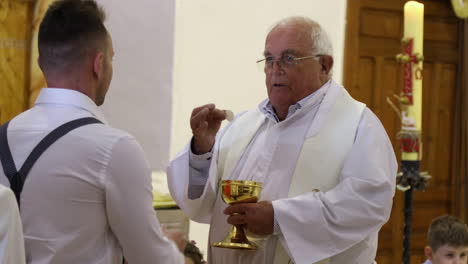 Priester,-Der-Während-Der-Spanischen-Primera-Kommunion-Das-Heilige-Brot-In-Der-Kirche-Weitergibt