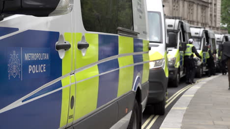 Police-officers-in-riot-uniforms-stand-by-waiting-Metropolitan-police-vans-during-a-public-order-event