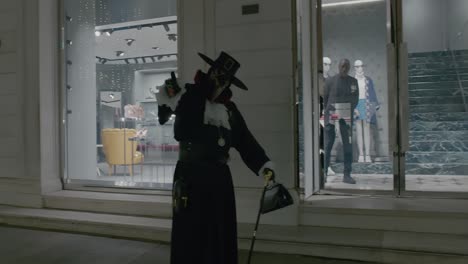 Person-wearing-a-traditional-Venetian-plague-doctor-costume-with-a-beaked-mask-in-Venice