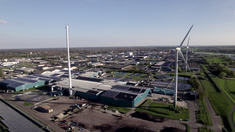 Pan-reveal-of-clean-energy-wind-turbines-solar-panels-and-water-purifying-facility-hub-in-agrarian-Dutch-landscape-seen-from-above