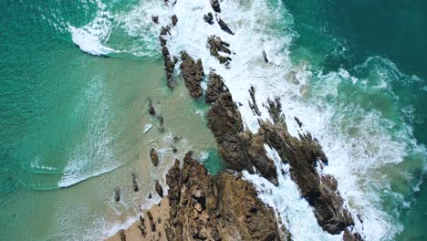 Video-De-Drones-De-4k,-Vista-Ariel-De-Las-Olas-Blancas-Rompiendo,-Mirando-Hacia-Abajo,-Volando-Hacia-Atrás,-Revelando-Las-Formaciones-Rocosas-Mientras-Las-Olas-Chocan-A-Su-Alrededor.