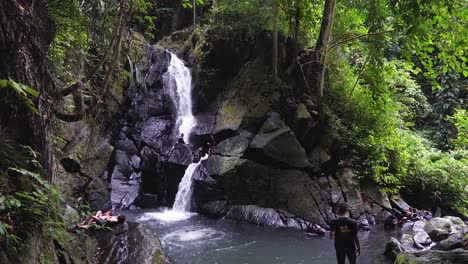 Young-people-diving,-fun-relaxation,-jungle-waterfall-tourist-attraction