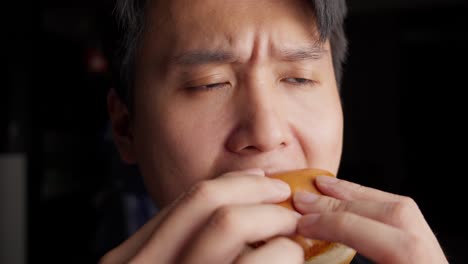 Individuo-Que-Consume-Una-Hamburguesa-De-Pescado-Frito-Cubierta-Con-Mayonesa-Y-Queso