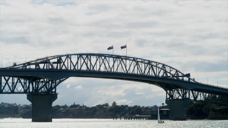 Einsames-Segelboot-Unter-Der-Hafenbrücke-Von-Auckland,-Neuseeland