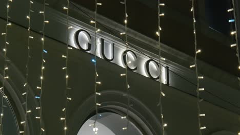 Fachada-Festiva-De-La-Tienda-Gucci-Con-Luces-Colgantes-Por-La-Noche-En-Venecia,-Italia