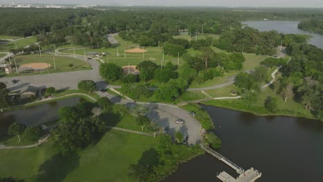 An-aerial-drone-flyover-of-Bay-Area-Park-featuring-Armand-Bayou,-recreation-paths,-and-baseball-diamonds-in-the-late-afternoon-on-Bay-Area-Blvd