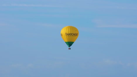 Globo-Aerostático-De-Sidra-Thatchers-Amarillo-Contra-El-Cielo-Azul-Volando-Sobre-Los-Niveles-De-Somerset