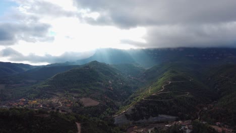 Majestuosa-Vista-De-Las-Montañas-De-Montserrat-Y-Marganell-Con-Rayos-De-Sol-Atravesando-Las-Nubes