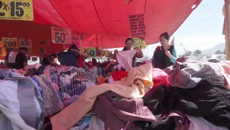 Adult-Latina-women-buying-second-hand-clothes-at-traditional-flea-market-in-urban-area-of-Mexico