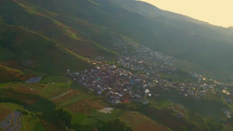 órbita-Aérea-Alrededor-De-Un-Pequeño-Pueblo-En-El-Campo-Indonesio-En-Una-Colina-Empinada