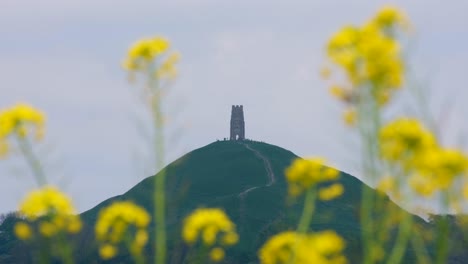 People-visiting-the-popular-attraction-of-The-Tor-in-the-rural-countryside-landscape-of-the-Somerset-Levels,-England-UK