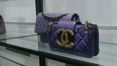 Chanel-luxury-purple-handbags-displayed-on-a-glass-shelf-in-a-high-end-boutique