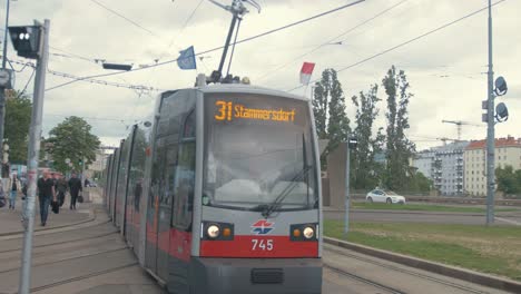 Pendler-Gehen-Zur-Straßenbahn,-Während-Diese-An-Einer-Kamera-Vorbeifährt
